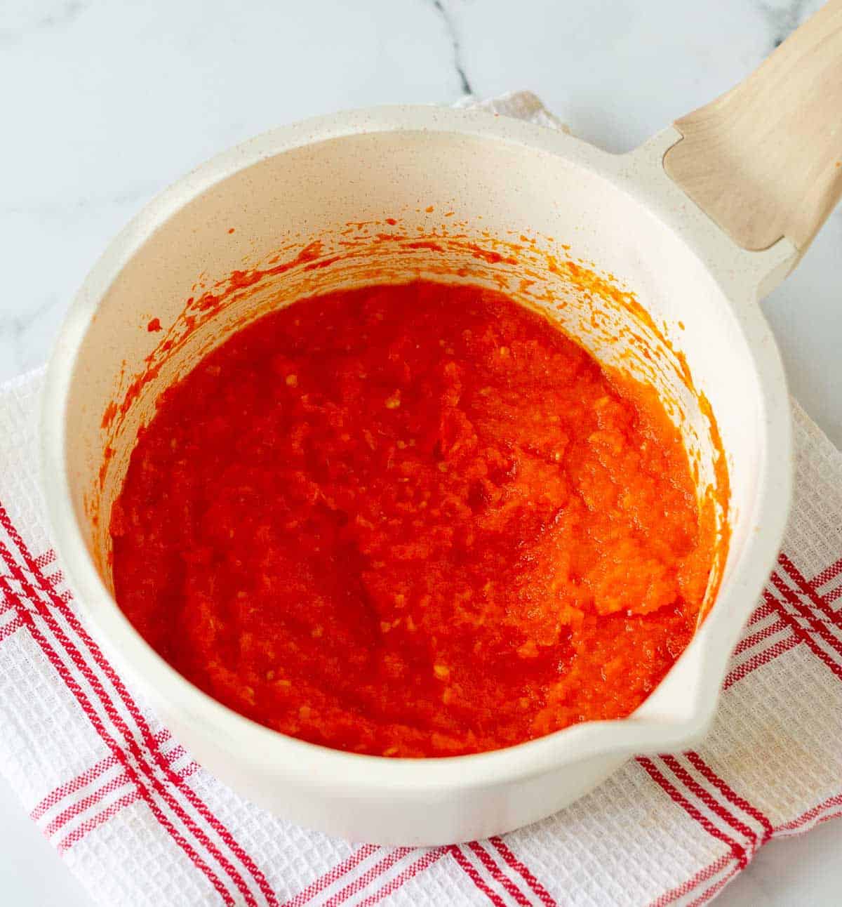 Cooked sambal oelek in a white saucepan.
