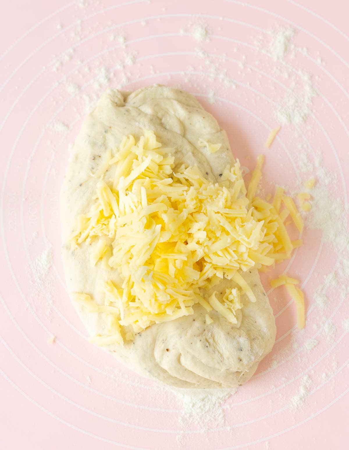 Shredded cheese on bread dough.
