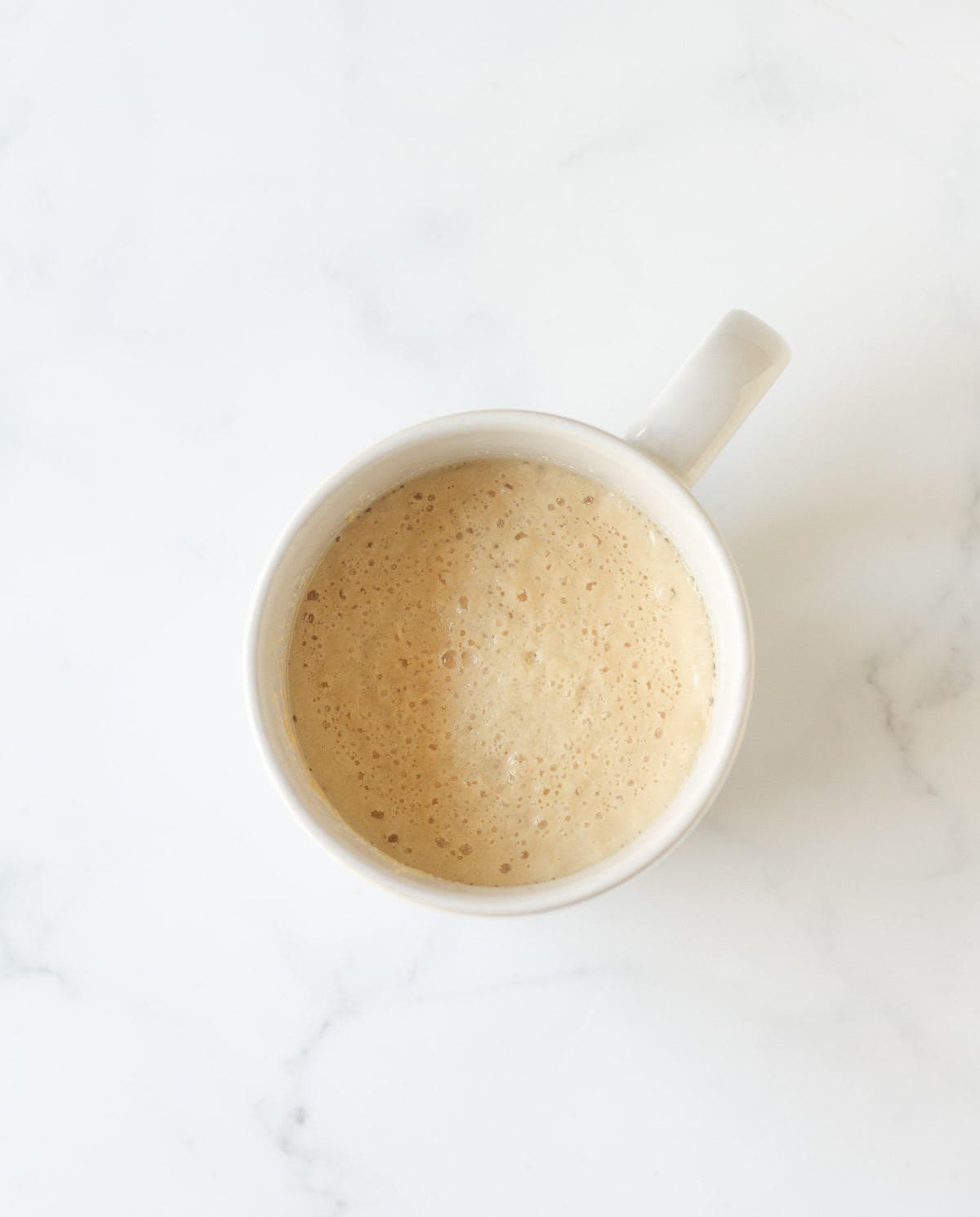 Bubbly yeast and water mixture in a cup.