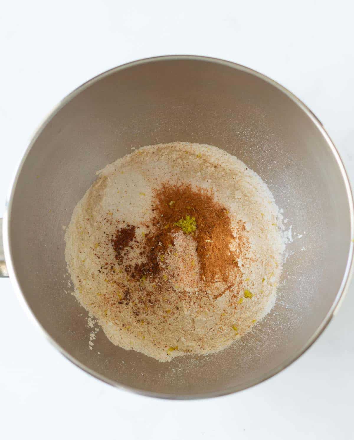Dry ingredients for hot cross buns in a stand mixer bowl.