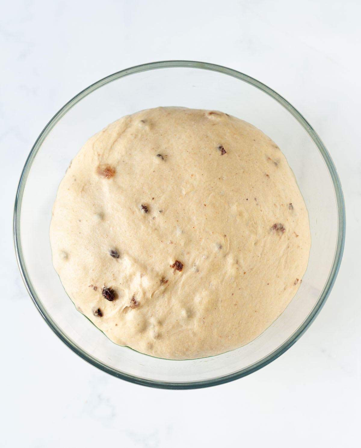 Proofed dough in a glass bowl.