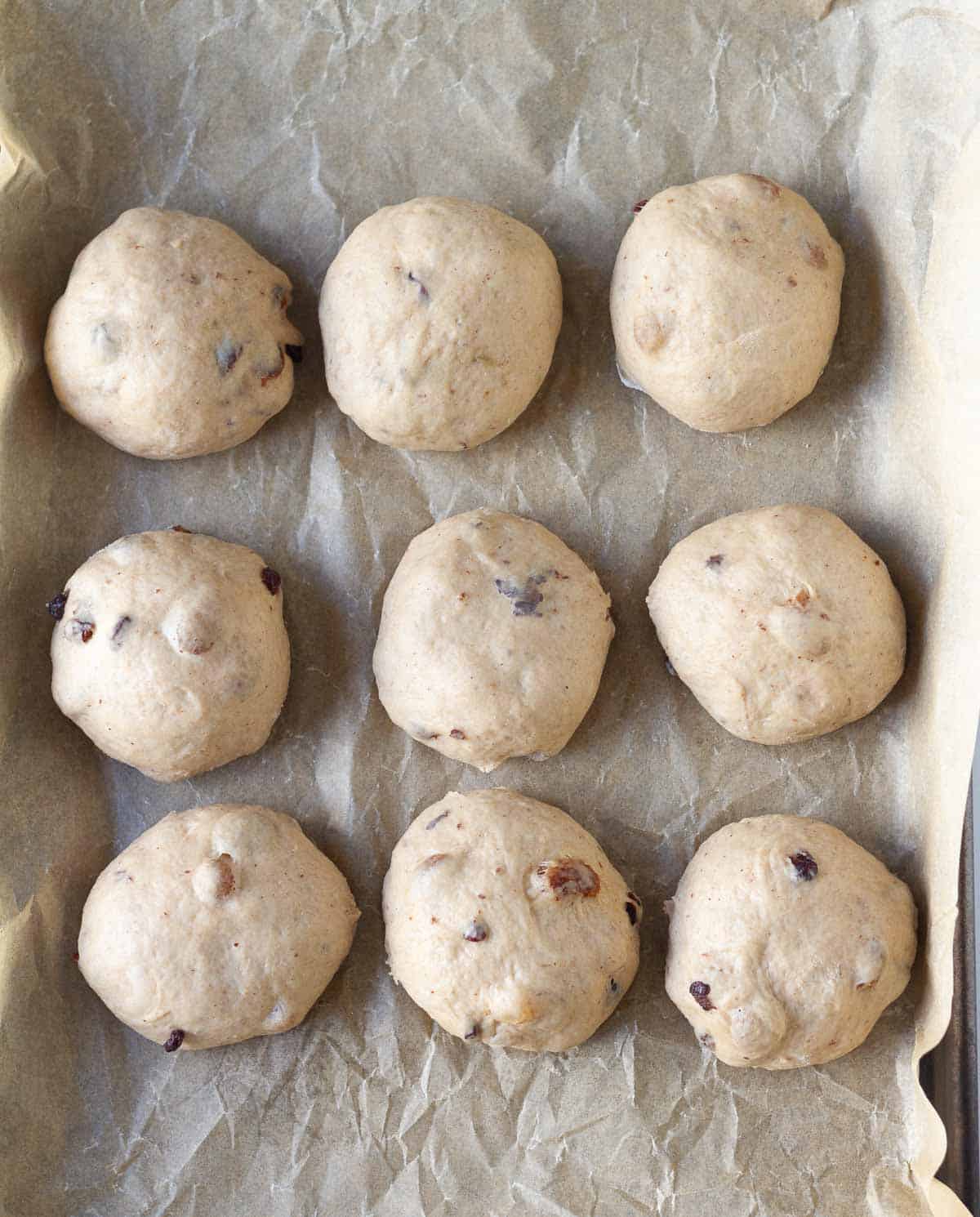 9 dough balls on a parchment-lined tray.