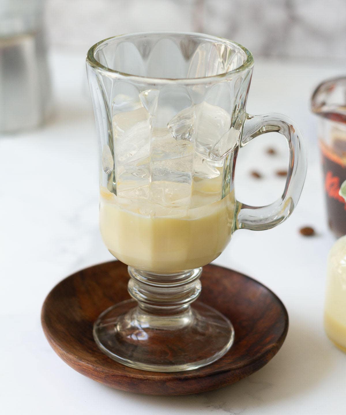 Ice cubes on top of condensed milk in a cup.