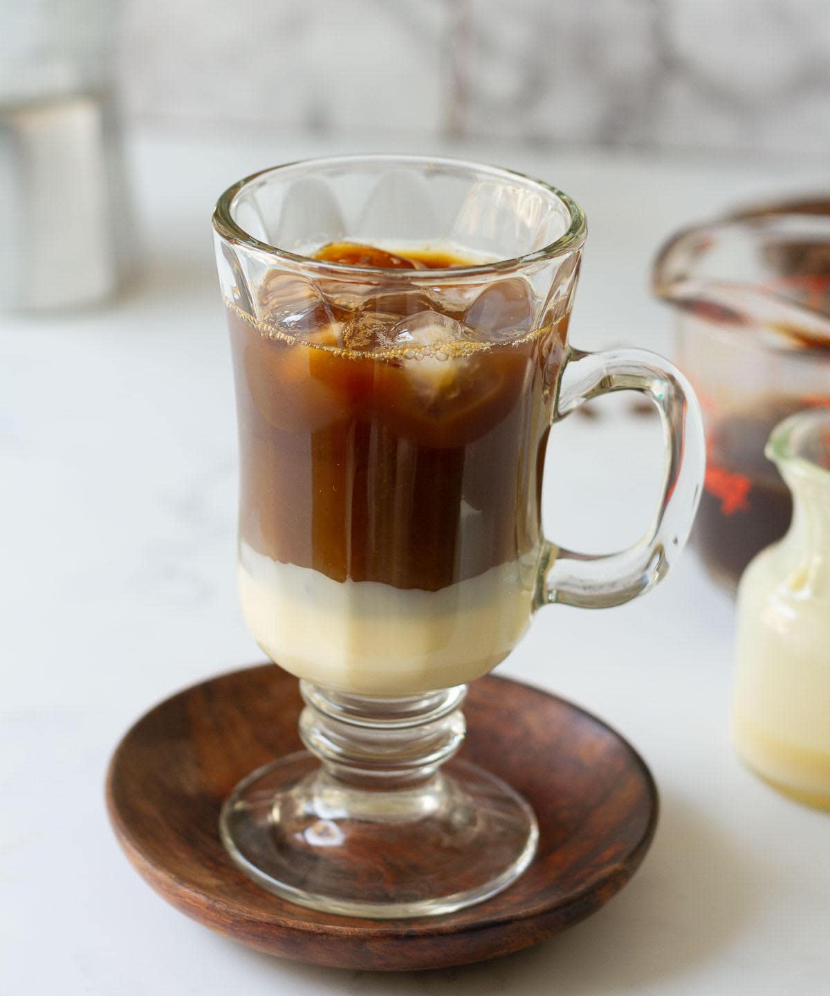 Brewed coffee on top of the ice and condensed milk in a cup.