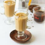 2 cups of Vietnamese iced coffee with ingredients in the background.