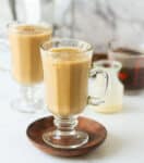 2 cups of iced coffee with ingredients in the background.