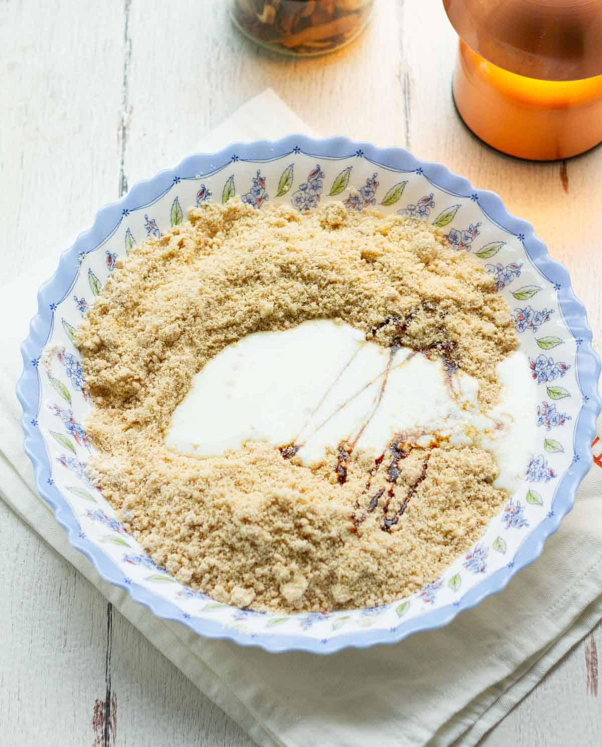 Buttermilk and vanilla extract on top of dry ingredients in a bowl.