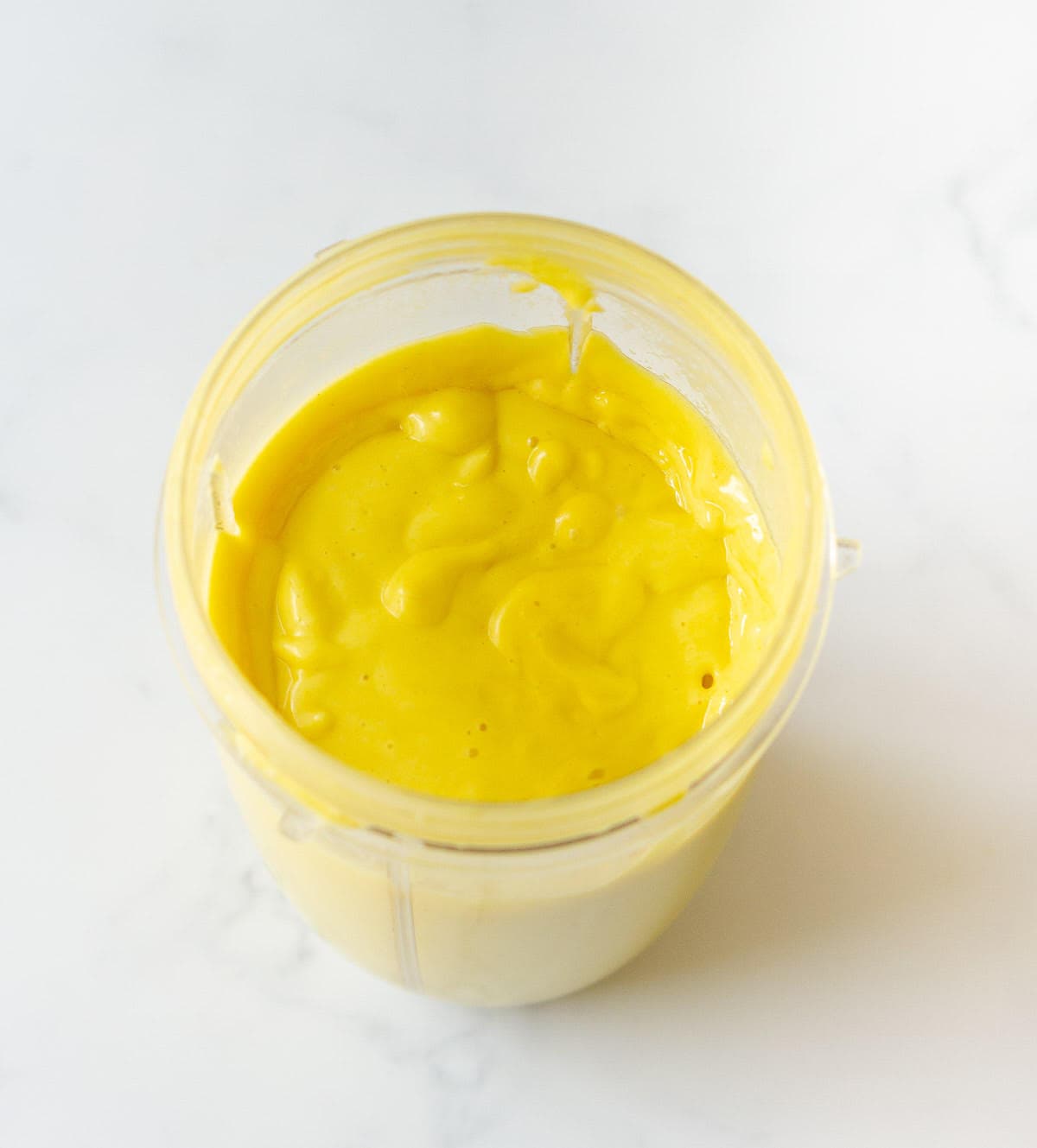 Blended coconut milk and mango mixture in a blender jar.