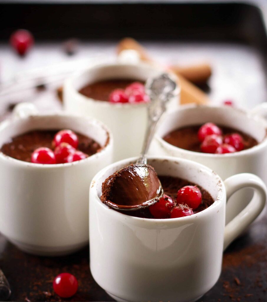 chocolate pudding being spooned out of a white cup.