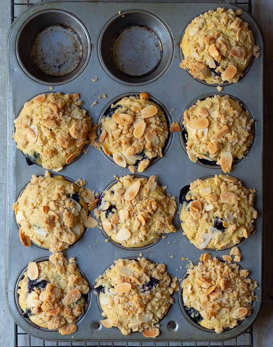 Baked muffins with streusel in a muffin tray.
