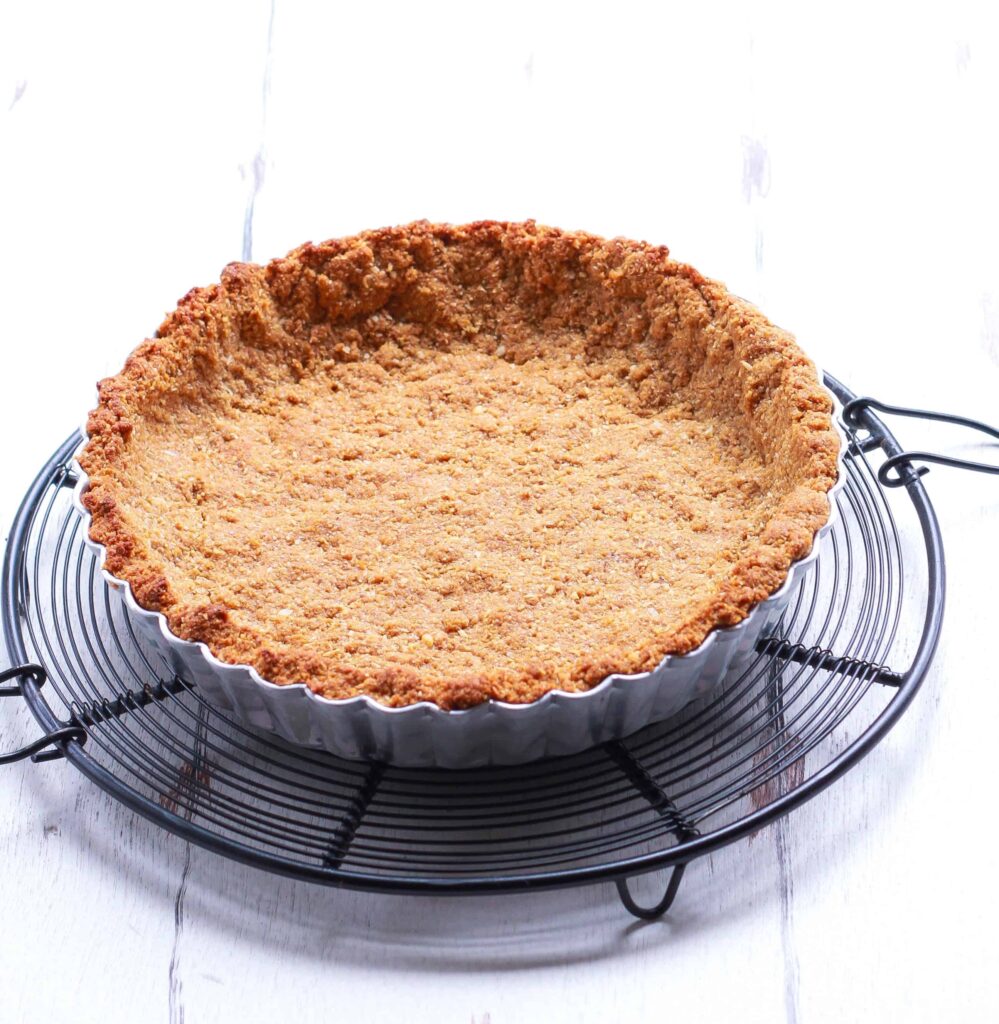 tart crust in a tart pan on a trivet.