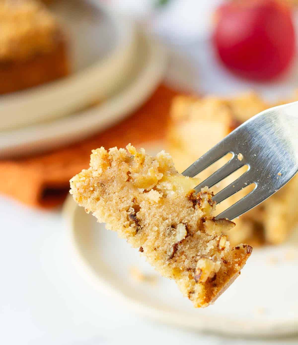 A bite of apple cake on a fork.