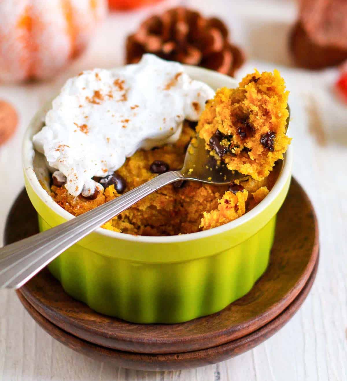 A bite of pumpkin mug cake on a spoon .