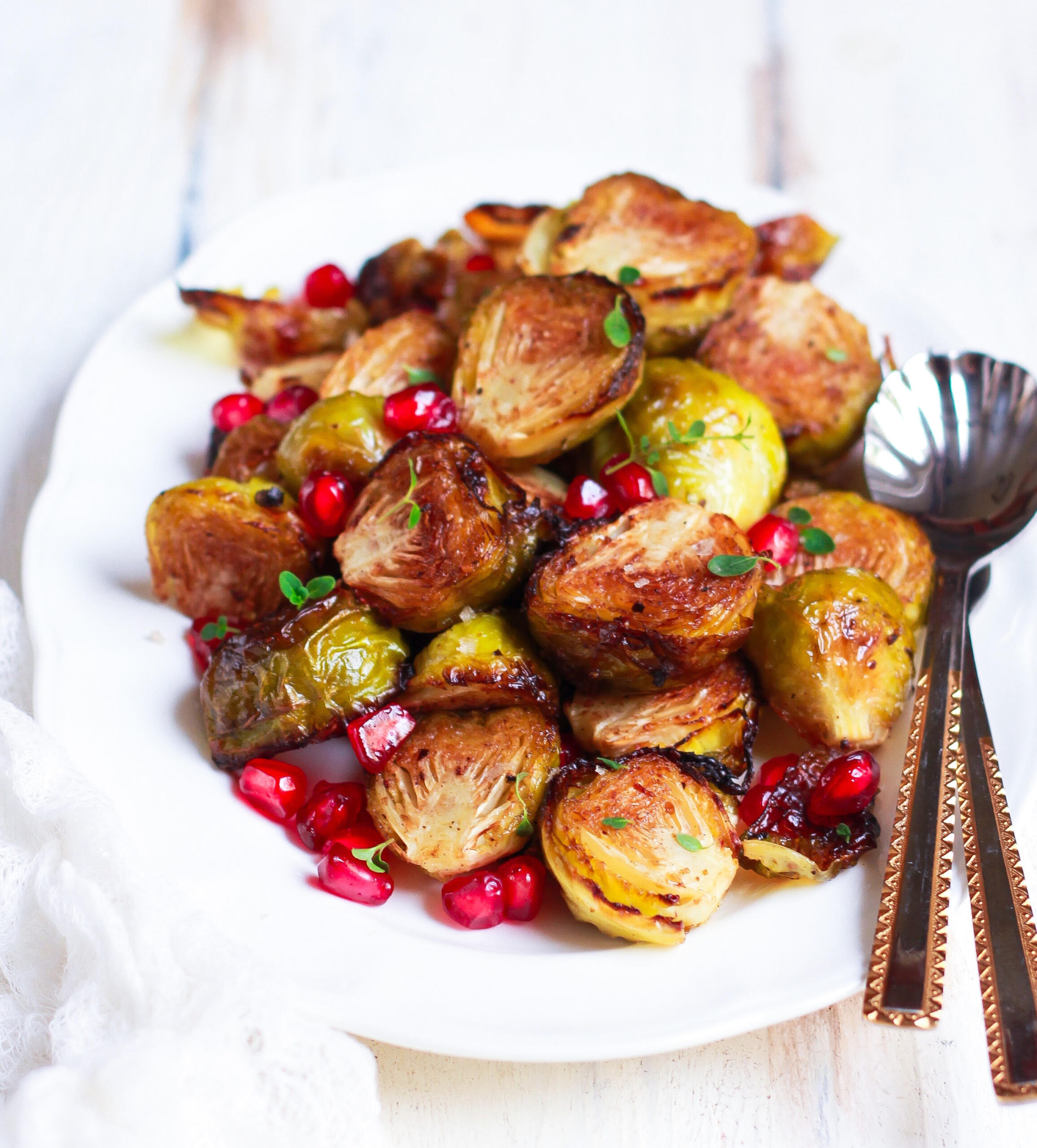 Roasted Brussels Sprouts in a serving platter with spoons.