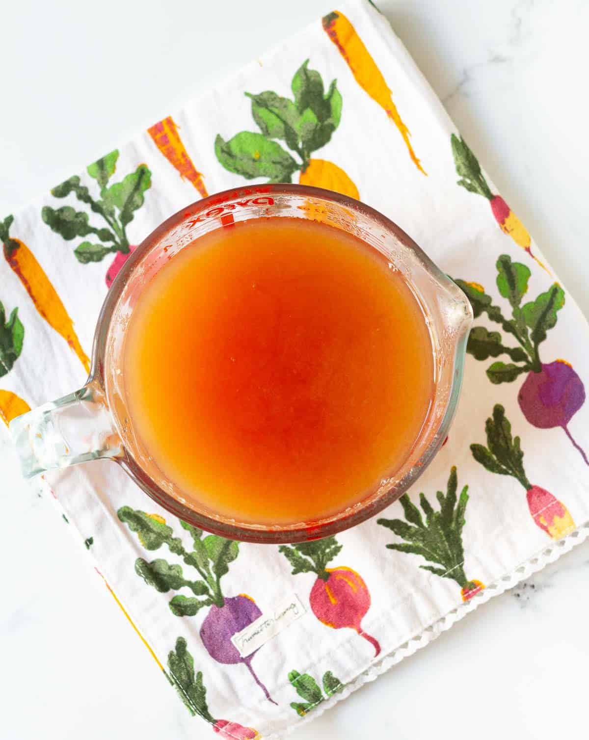 Strained apple cider in a glass measuring cup.