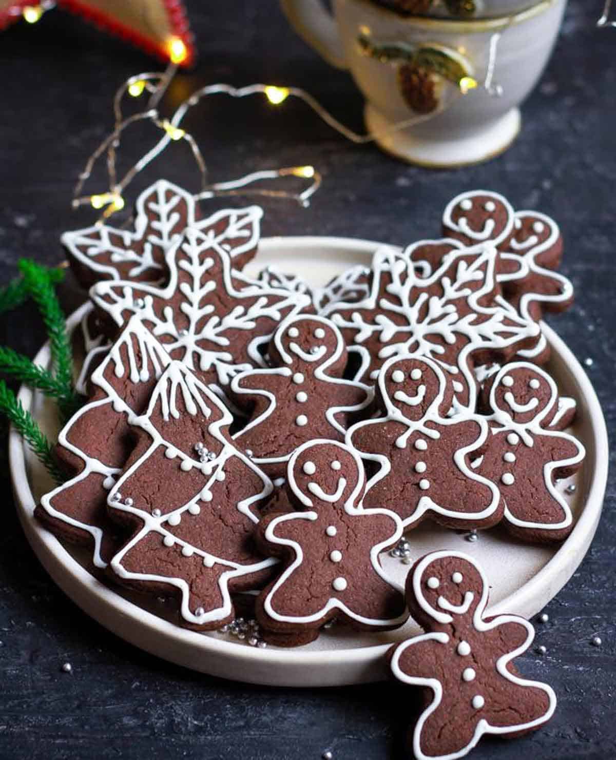 gingerbread cookies on a platter with string light and christmas decorations.