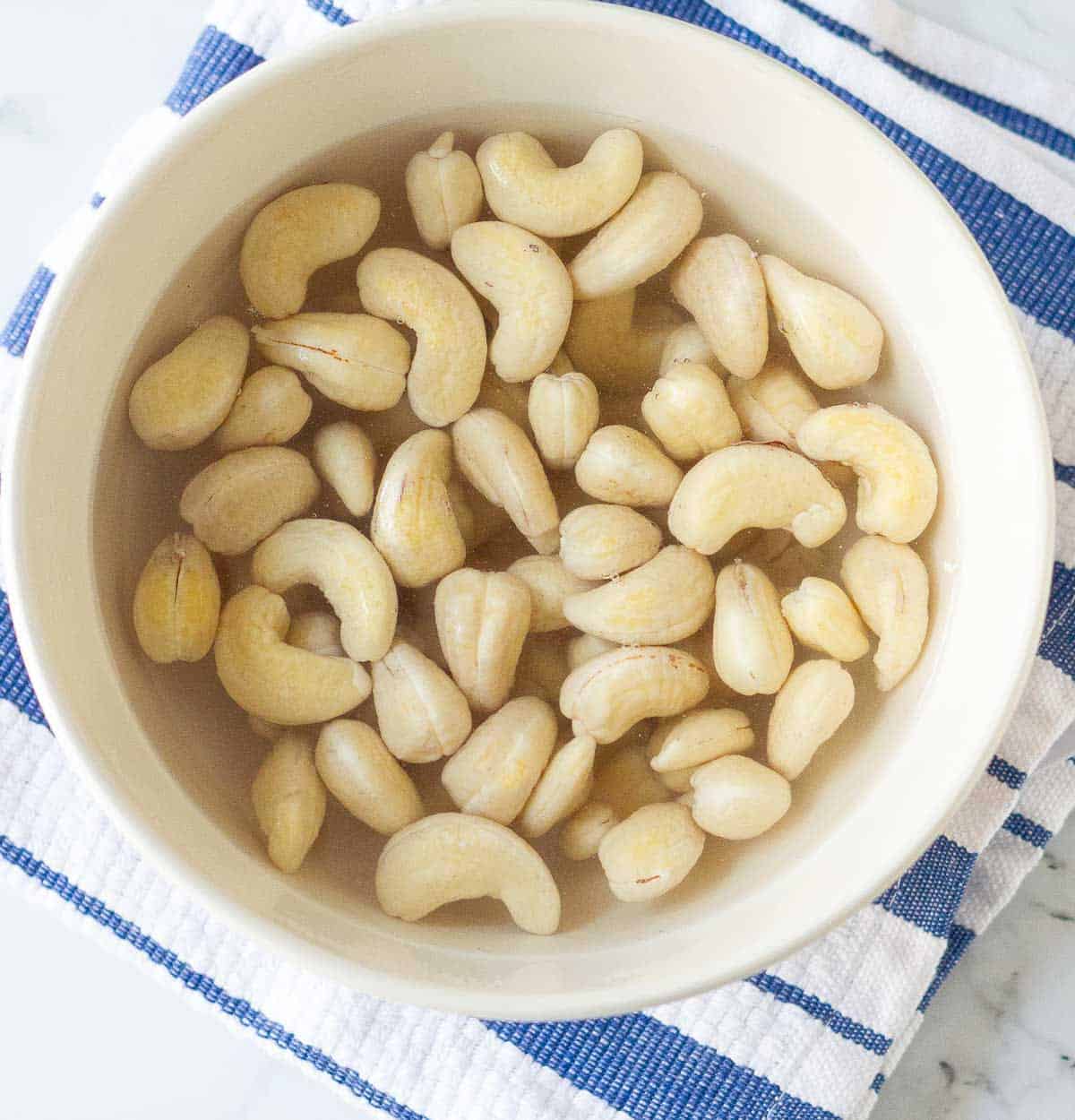 cashews soaked in water in a bowl.