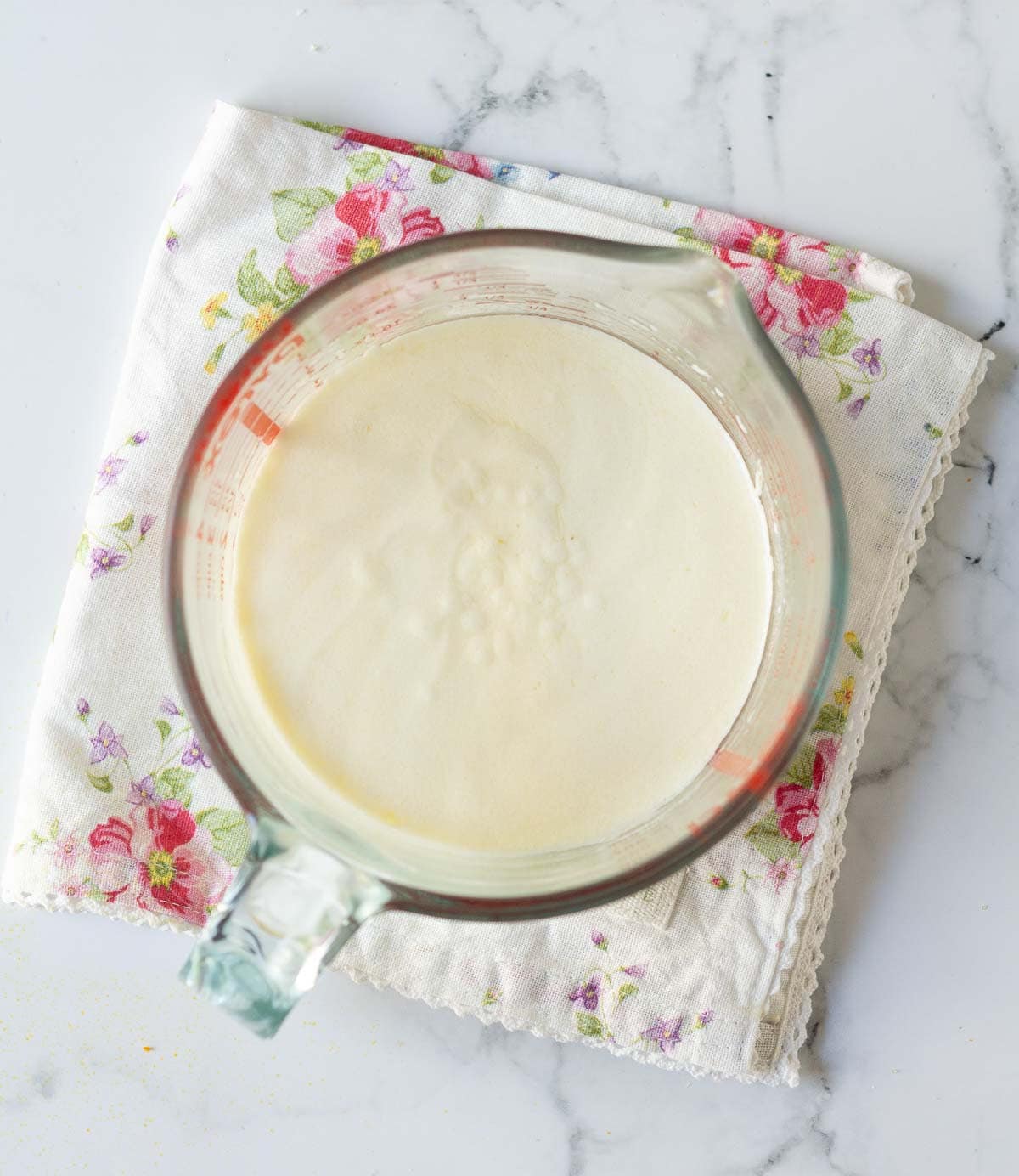 Yogurt, orange juice, and olive oil mixture in a measuring cup.