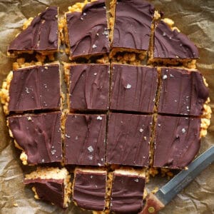 Peanut butter Rice Krispie squares cut into pieces on parchment paper.