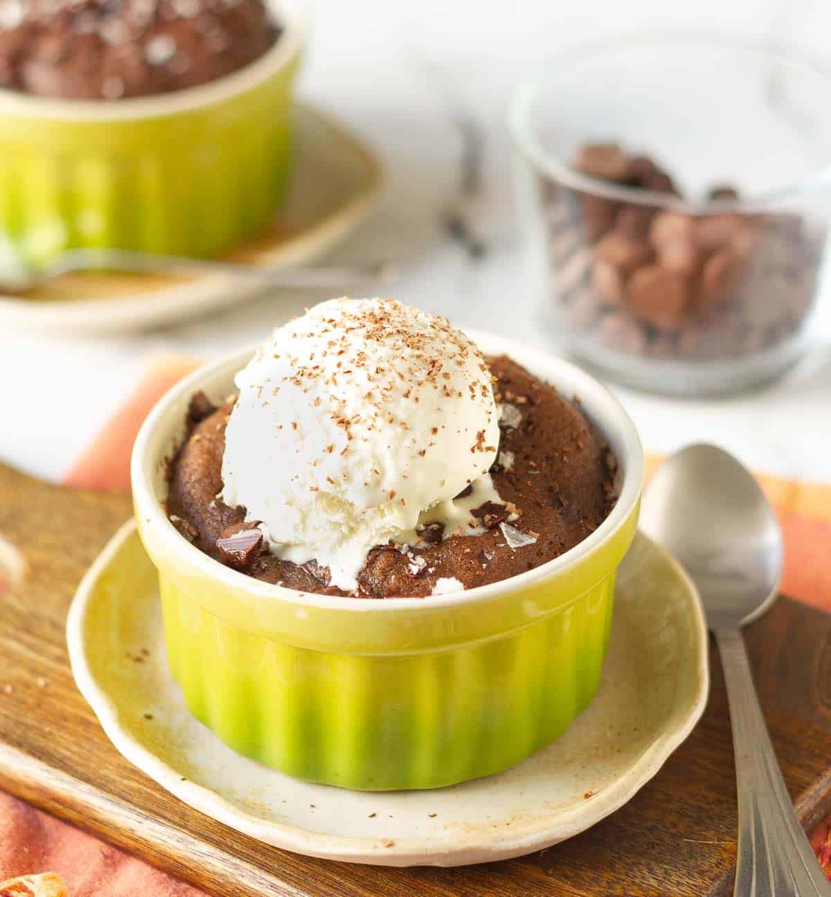 brownie in a ramekin with a scoop of vanilla ice cream and chocolate shavings.