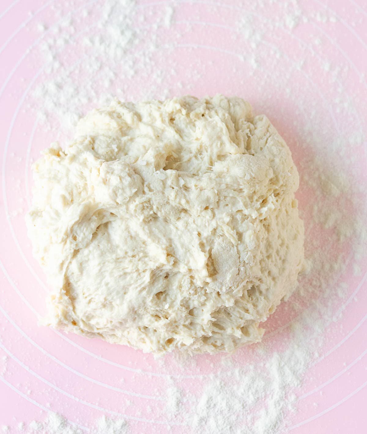 A shaggy dough for the bread on a pink silicone mat.