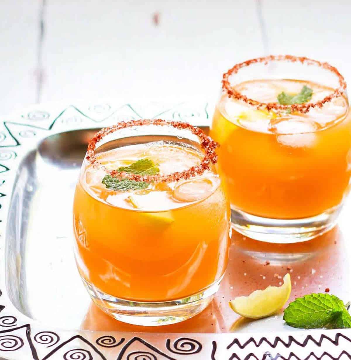 2 glasses of mango cocktails on a silver tray.