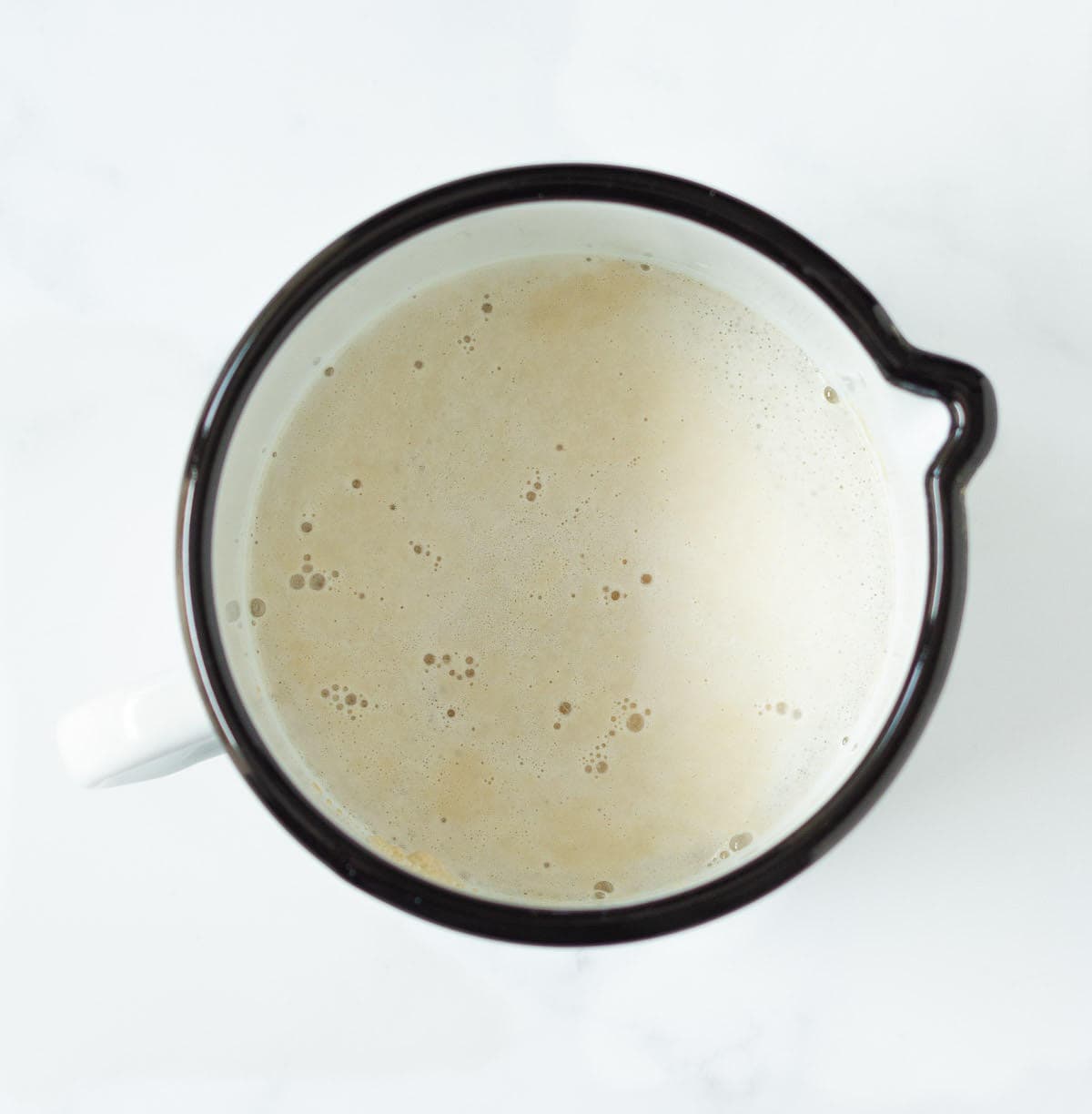 Bubbly yeast water mixture in a cup.