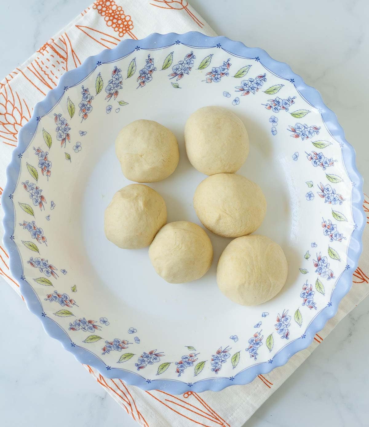 6 dough balls in a bowl.