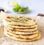 A stack of naans on parchment paper.