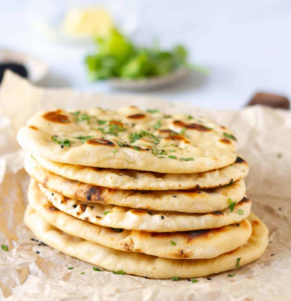 A stack of naans on parchment paper.