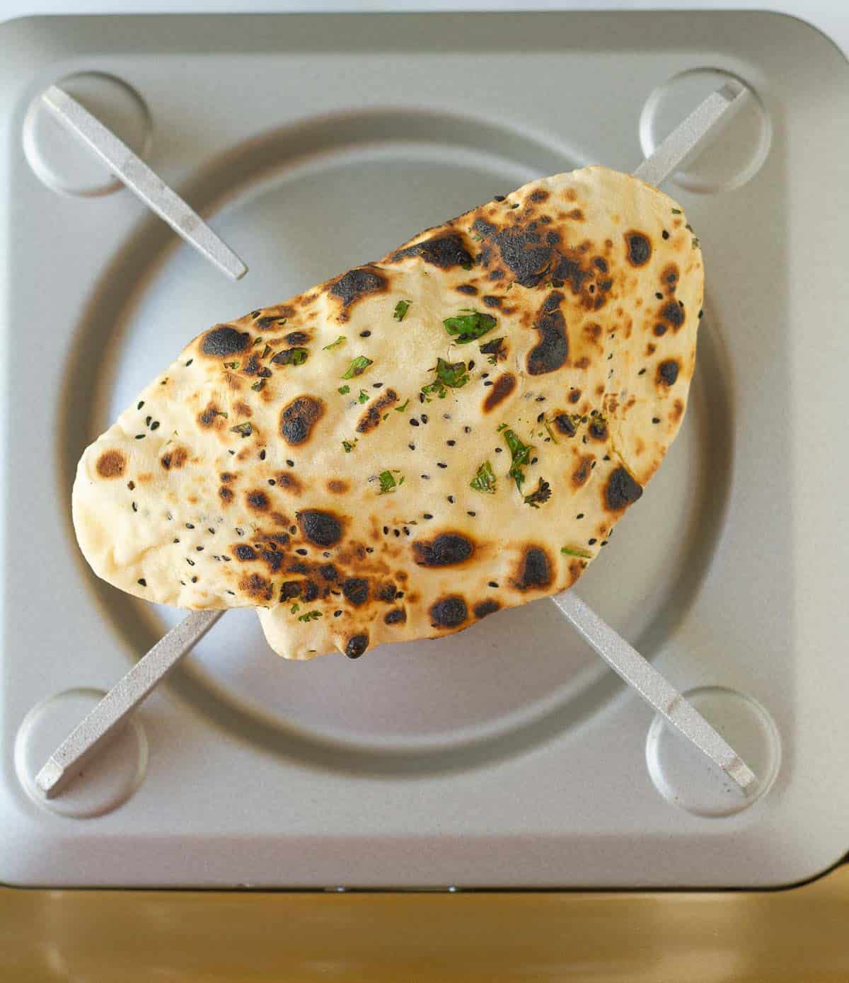 A cooked naan on stove top.