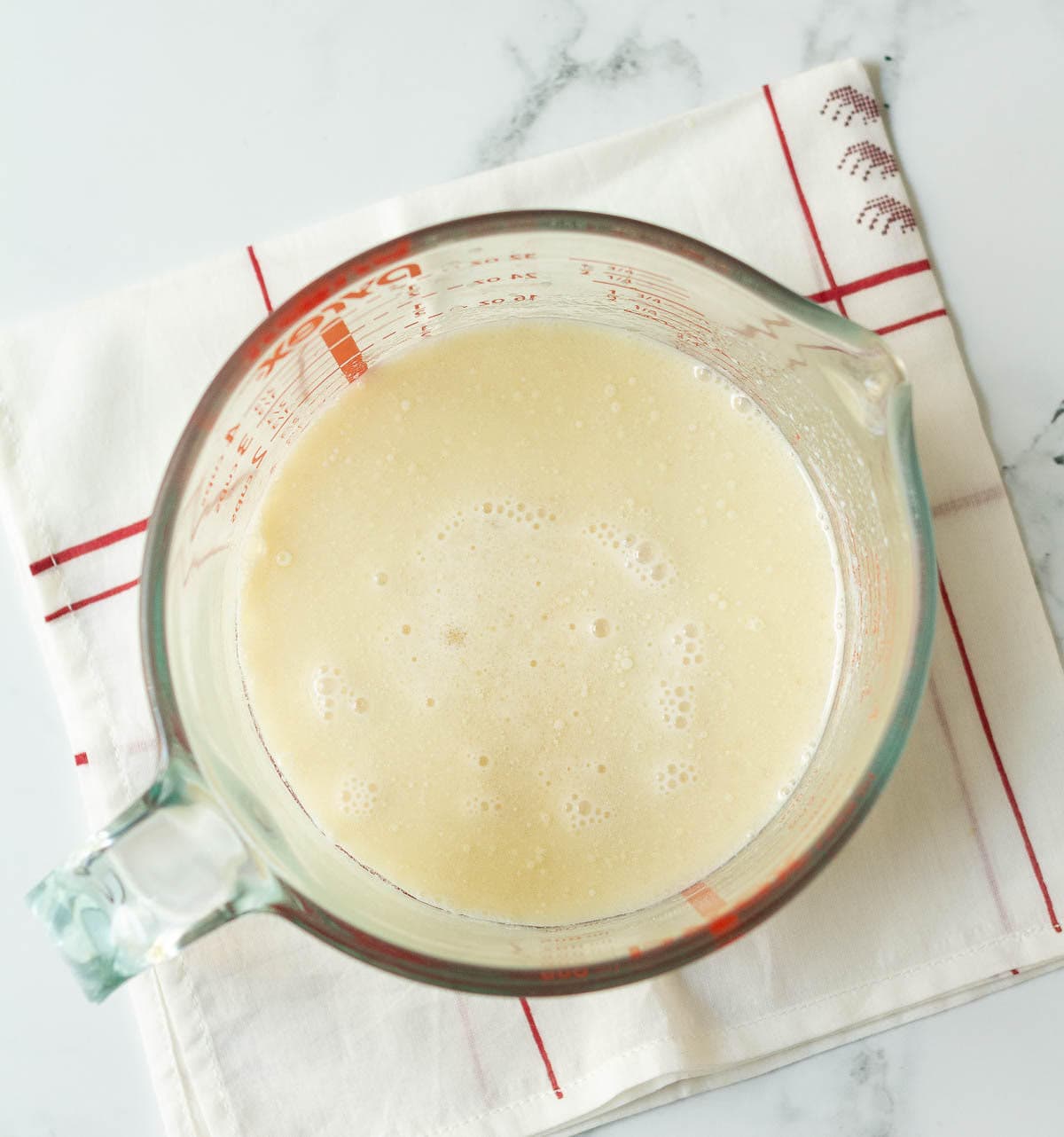 Wet ingredients for a cake in a measuring cup.