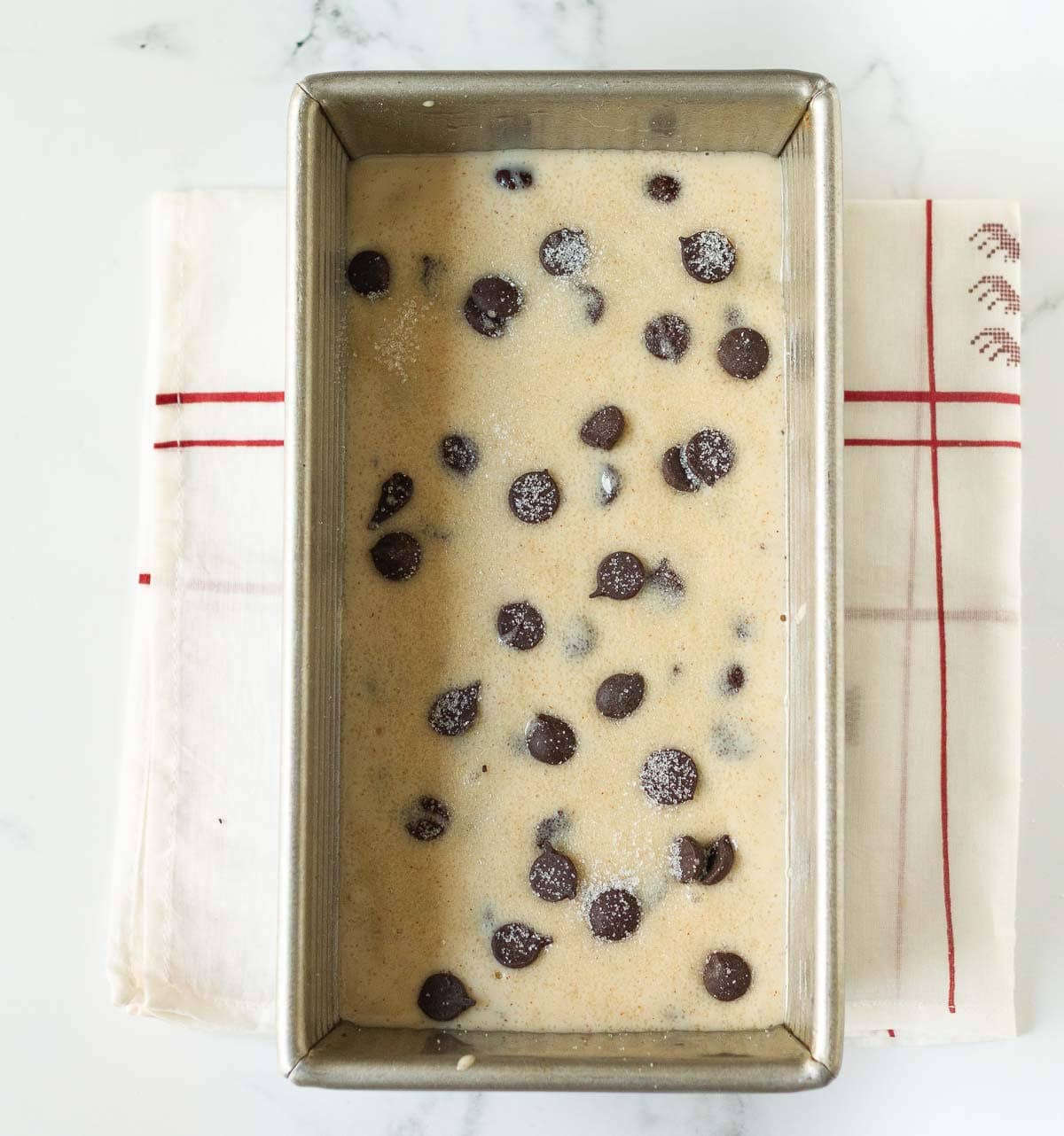Cake batter with chocolate chips in a loaf pan.
