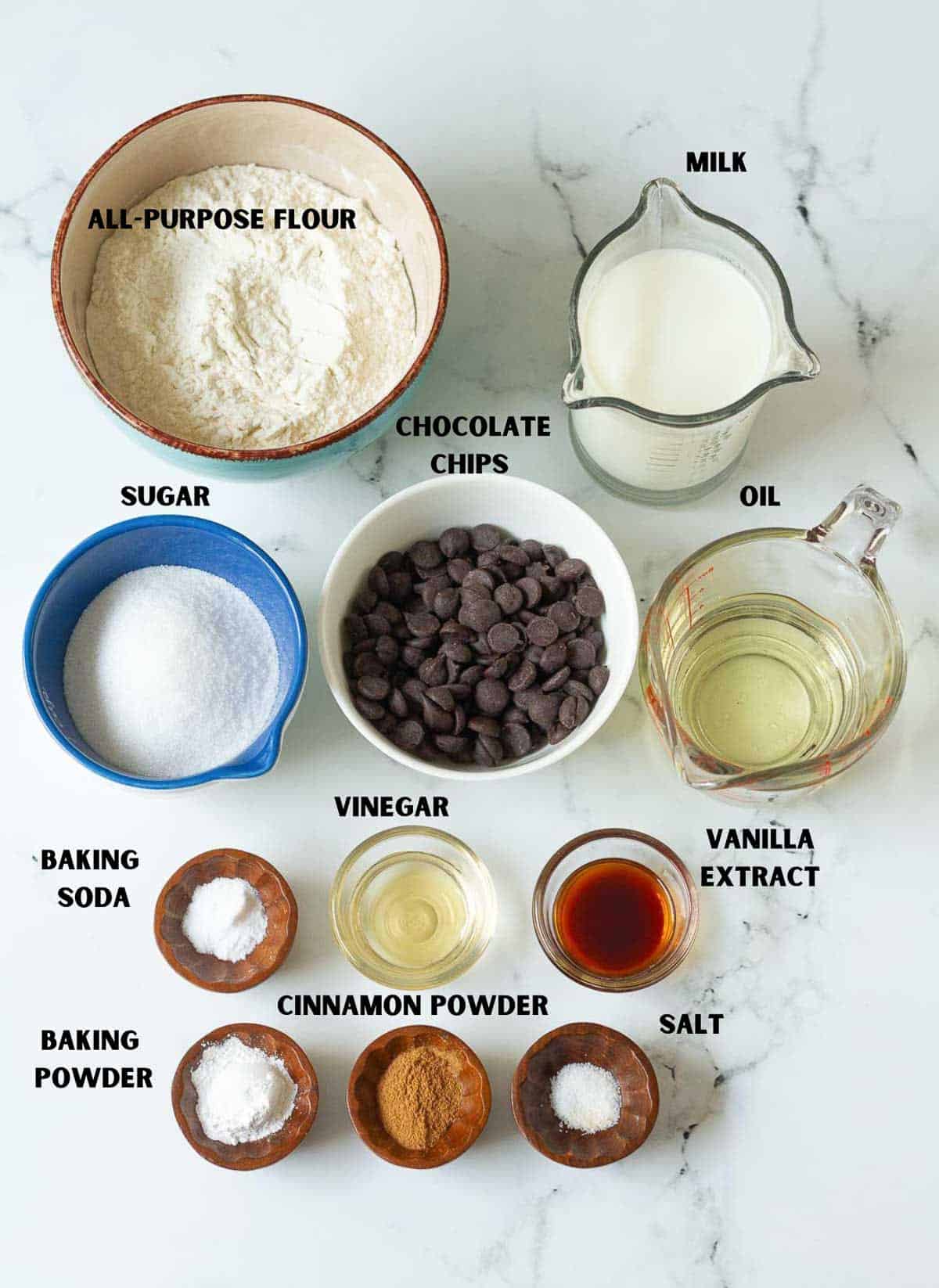 Labelled ingredients for making eggless chocolate chip cake.