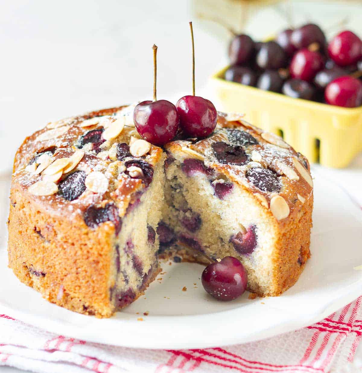 Cherry cake with a slice taken out to show the cross-section.