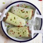 3 pistachio matcha popsicles in a small tray.