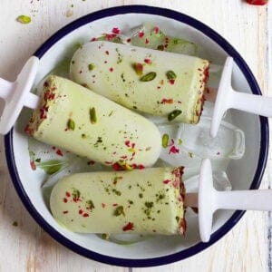 3 pistachio matcha popsicles in a small tray.