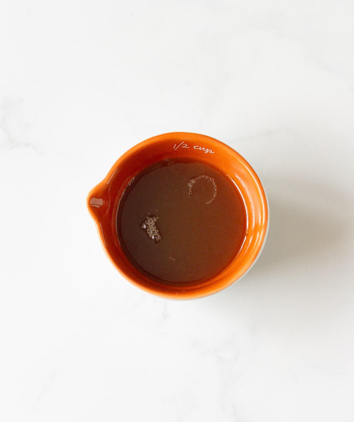 Honey syrup in a small orange bowl.