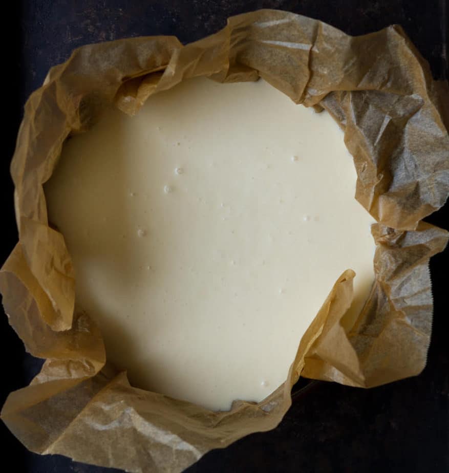cheesecake batter in a parchment-lined cake tin.