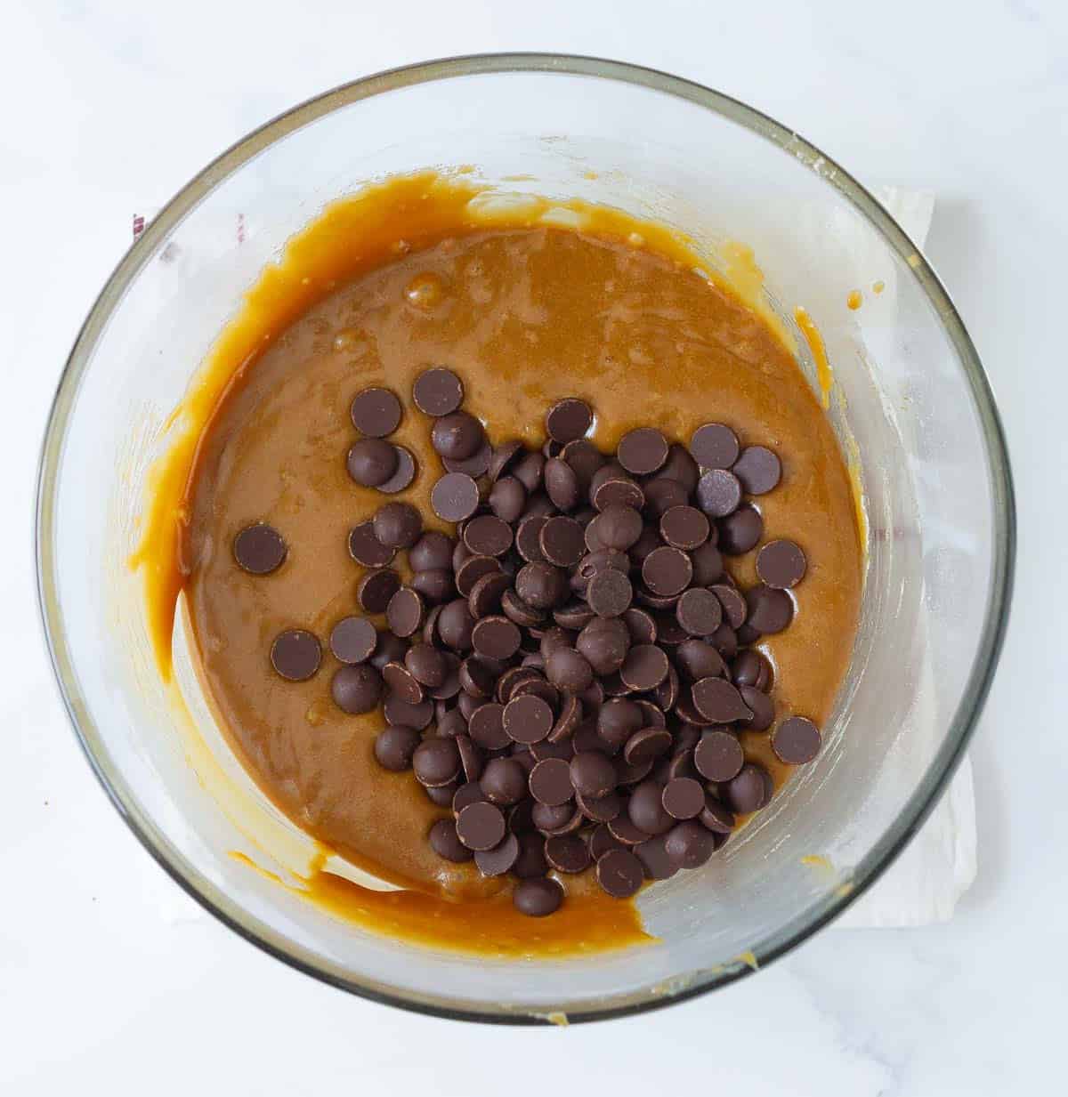 Chocolate chips on top of batter in a bowl.