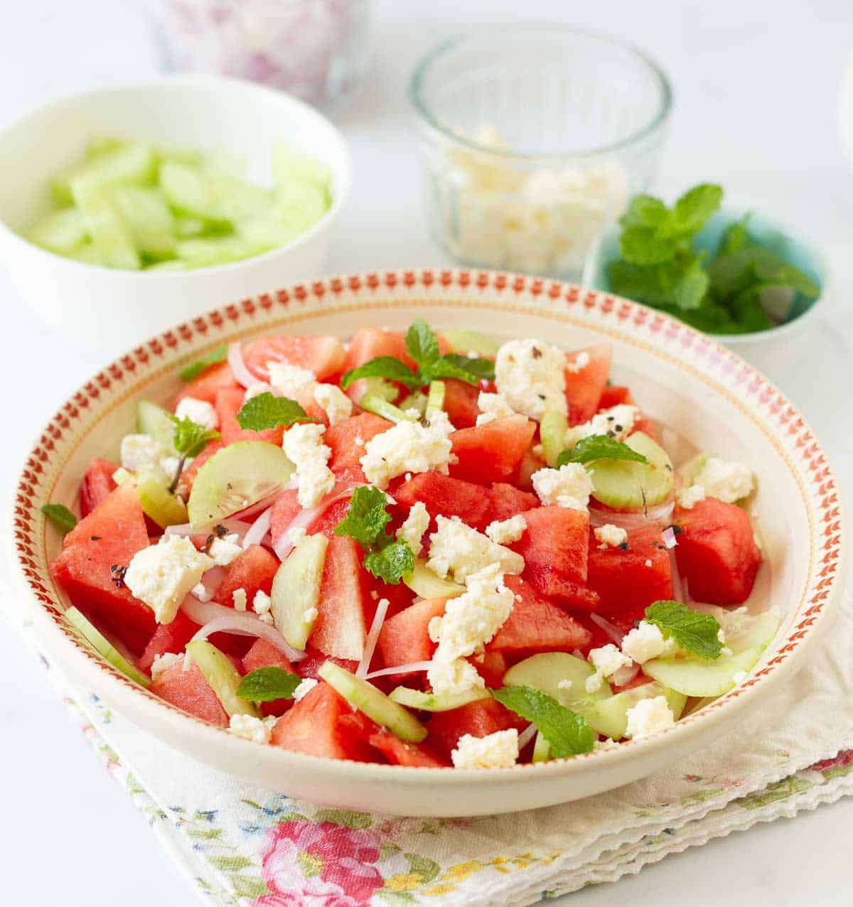 Watermelon and feta salad garnished with mint leaves in a bowl.