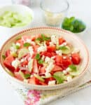 Watermelon and feta salad garnished with mint leaves in a bowl.