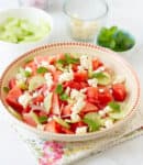 Watermelon and feta salad garnished with mint leaves in a bowl.