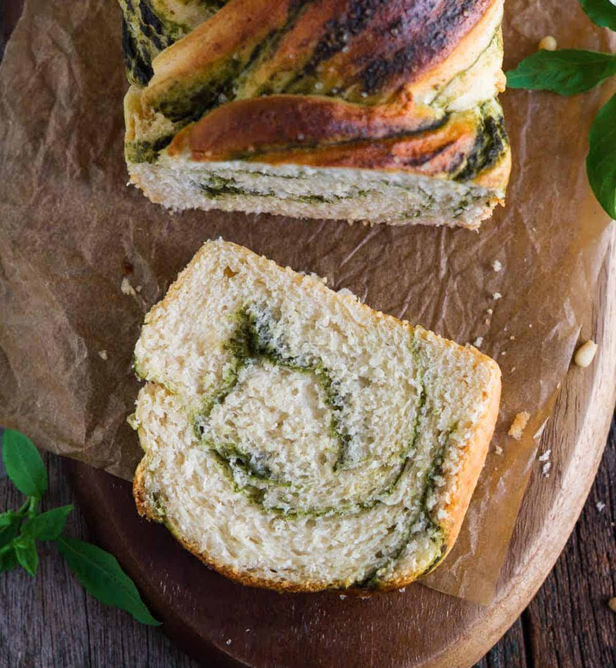 A slice of pesto bread on a wooden board.