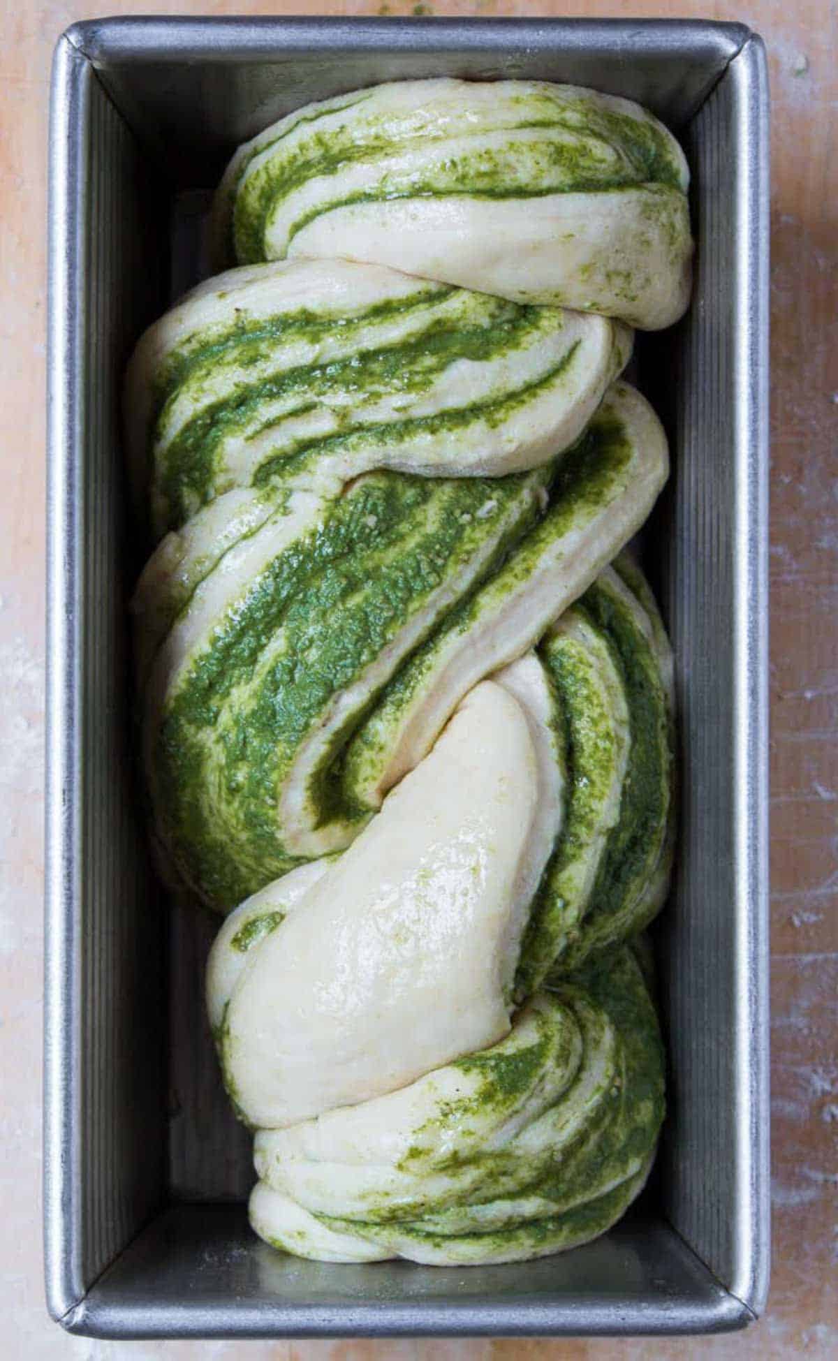 Braided bread dough in a baking pan.