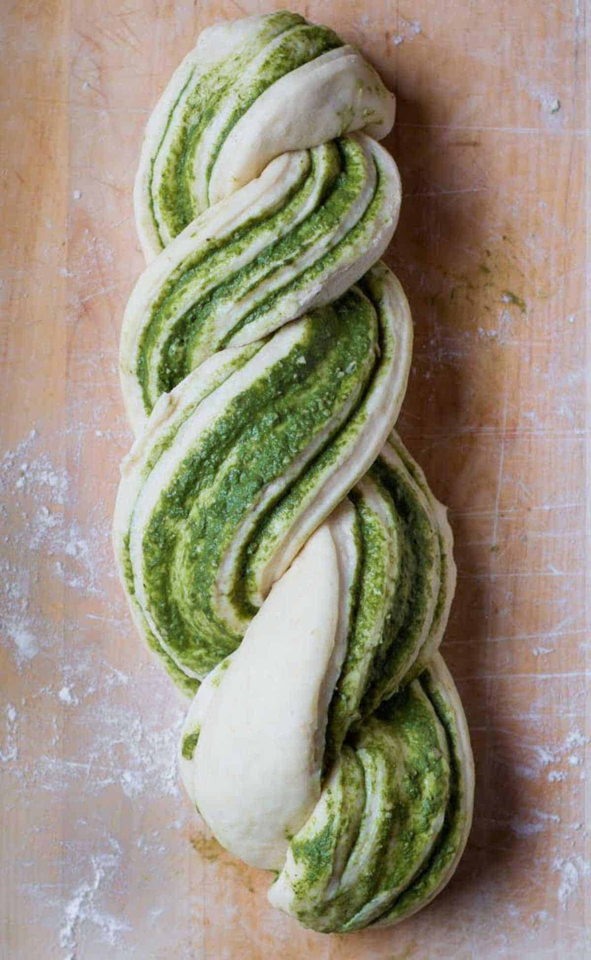 Pesto bread dough twisted into a braid.