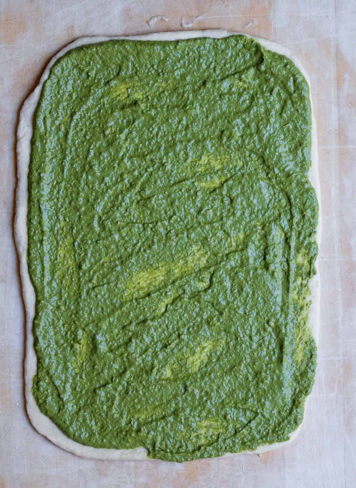 Pesto spread on the rolled out dough.