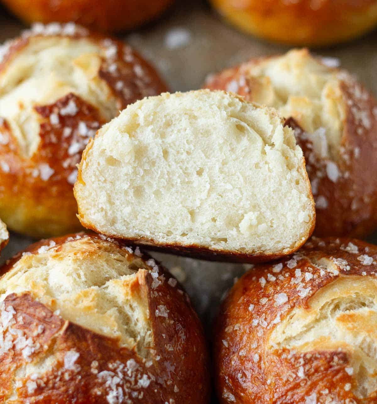 Half of a bread roll to show the cross section placed on more rolls.