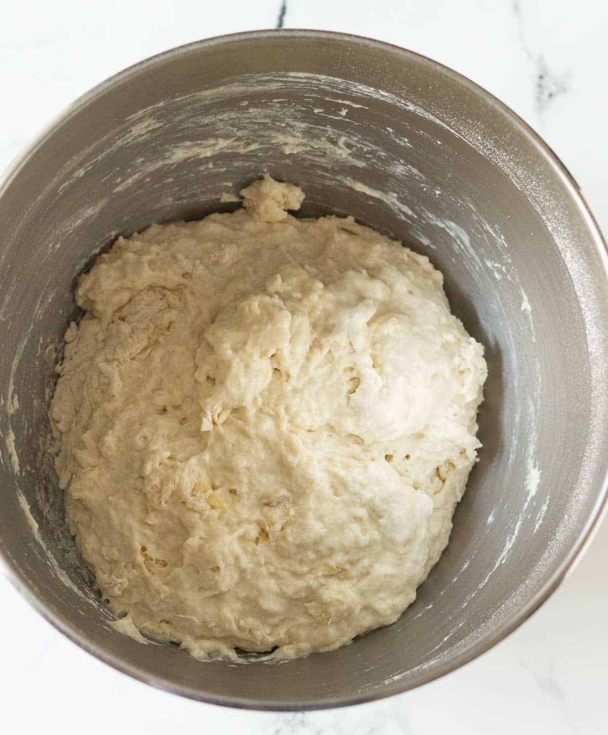 a shaggy dough in a stand mixer's bowl.