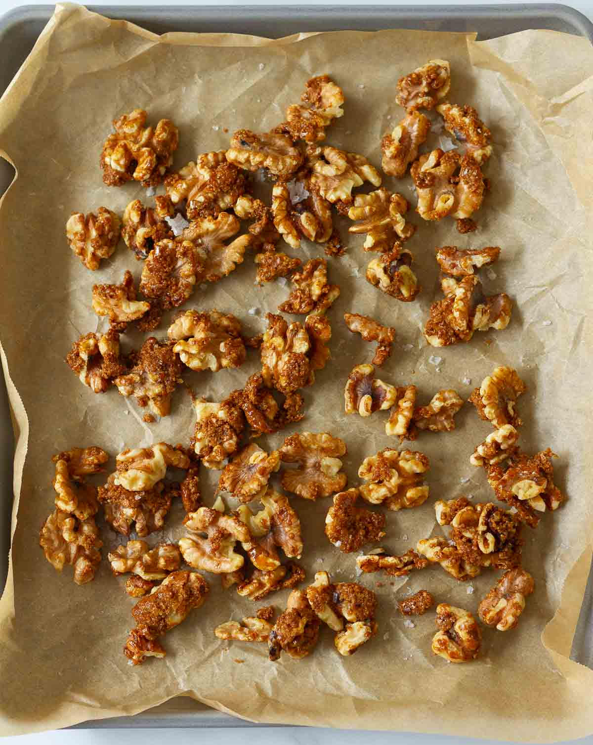 candied walnuts on a parchment lined tray.